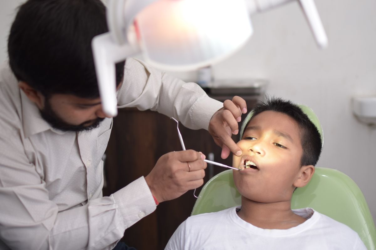 Dentist applying preventive sealant to a young patient's molar